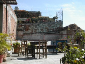 a partial wall of re-used green stone at the hostel